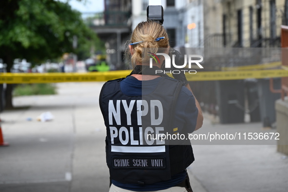 A New York City Police Department crime scene unit officer collects evidence at the scene. A 37-year-old male is shot and killed in Brooklyn...