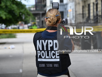 A New York City Police Department crime scene unit officer collects evidence at the scene. A 37-year-old male is shot and killed in Brooklyn...