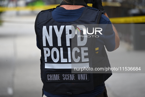 An NYPD Police Crime Scene Unit vest is on a police officer at the scene. A 37-year-old male is shot and killed in Brooklyn, New York, Unite...