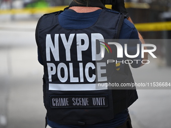 An NYPD Police Crime Scene Unit vest is on a police officer at the scene. A 37-year-old male is shot and killed in Brooklyn, New York, Unite...