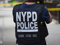 An NYPD Police Crime Scene Unit vest is on a police officer at the scene. A 37-year-old male is shot and killed in Brooklyn, New York, Unite...