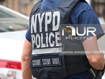 A New York City Police Department crime scene unit officer wears an NYPD crime scene unit vest at the crime scene. A 37-year-old male is sho...