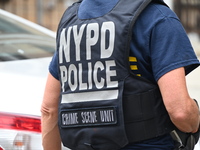 A New York City Police Department crime scene unit officer wears an NYPD crime scene unit vest at the crime scene. A 37-year-old male is sho...