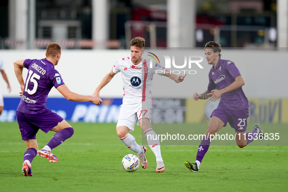 Georgios Kyriakopoulos of AC Monza is challenged by Pietro Comuzzo of ACF Fiorentina during the Serie A Enilive match between ACF Fiorentina...