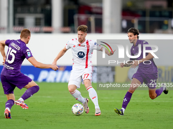 Georgios Kyriakopoulos of AC Monza is challenged by Pietro Comuzzo of ACF Fiorentina during the Serie A Enilive match between ACF Fiorentina...