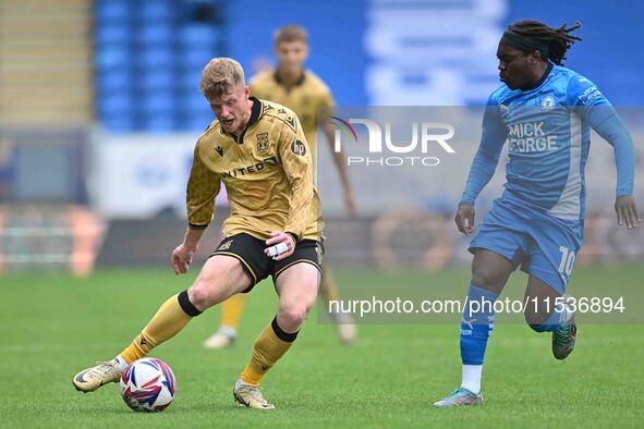 Andy Cannon (8 Wrexham) is challenged by Abraham Odoh (10 Peterborough United) during the Sky Bet League 1 match between Peterborough and Wr...