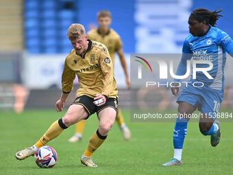 Andy Cannon (8 Wrexham) is challenged by Abraham Odoh (10 Peterborough United) during the Sky Bet League 1 match between Peterborough and Wr...