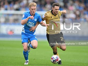 Ryan Barnett (29, Wrexham) challenges Jack Sparkes (21, Peterborough United) for the ball during the Sky Bet League 1 match between Peterbor...