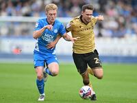 Ryan Barnett (29, Wrexham) challenges Jack Sparkes (21, Peterborough United) for the ball during the Sky Bet League 1 match between Peterbor...