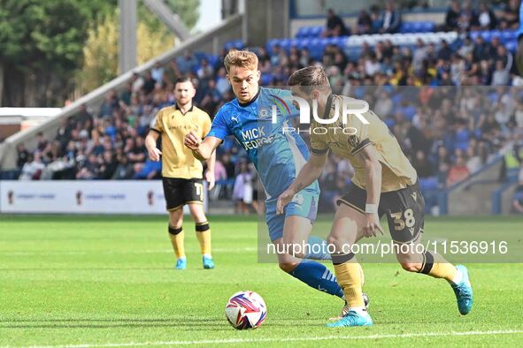 Elliot Lee (38 Wrexham) is challenged by Archie Collins (4 Peterborough United) during the Sky Bet League 1 match between Peterborough and W...