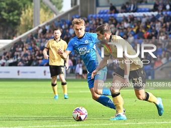 Elliot Lee (38 Wrexham) is challenged by Archie Collins (4 Peterborough United) during the Sky Bet League 1 match between Peterborough and W...