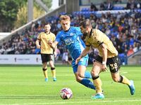 Elliot Lee (38 Wrexham) is challenged by Archie Collins (4 Peterborough United) during the Sky Bet League 1 match between Peterborough and W...