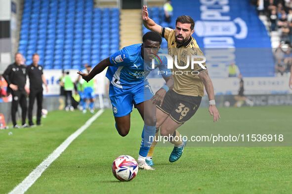 Kwame Poku (11 Peterborough United) is challenged by Elliot Lee (38 Wrexham) during the Sky Bet League 1 match between Peterborough and Wrex...