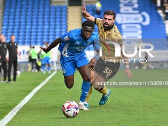 Kwame Poku (11 Peterborough United) is challenged by Elliot Lee (38 Wrexham) during the Sky Bet League 1 match between Peterborough and Wrex...