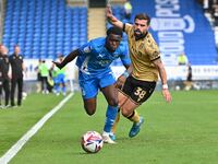 Kwame Poku (11 Peterborough United) is challenged by Elliot Lee (38 Wrexham) during the Sky Bet League 1 match between Peterborough and Wrex...