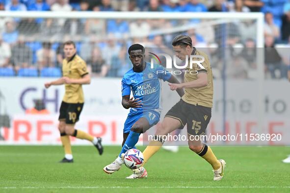 George Dobson (15 Wrexham) is challenged by Kwame Poku (11 Peterborough United) during the Sky Bet League 1 match between Peterborough and W...