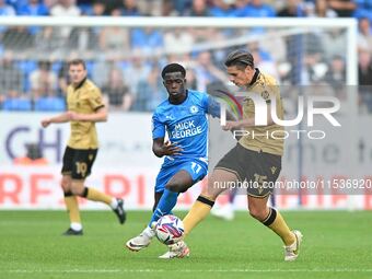 George Dobson (15 Wrexham) is challenged by Kwame Poku (11 Peterborough United) during the Sky Bet League 1 match between Peterborough and W...