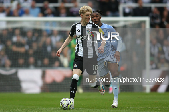 Newcastle United's Anthony Gordon breaks away from Tottenham Hotspur's Destiny Udogie during the Premier League match between Newcastle Unit...