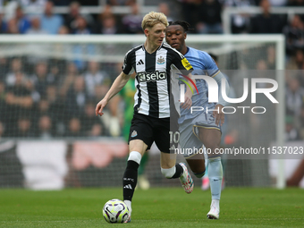 Newcastle United's Anthony Gordon breaks away from Tottenham Hotspur's Destiny Udogie during the Premier League match between Newcastle Unit...