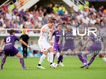 Milan Djuric of AC Monza is challenged by Cristiano Biraghi of ACF Fiorentina during the Serie A Enilive match between ACF Fiorentina and AC...