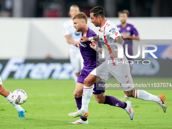 Lucas Beltran of ACF Fiorentina and Armando Izzo of AC Monza compete for the ball during the Serie A Enilive match between ACF Fiorentina an...