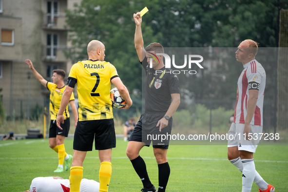 Referee Tomasz Wajda shows a yellow card to Michal Pazdan during a game between Wieczysta Krakow and Pogon Grodzisk Mazowiecki in Krakow, Po...