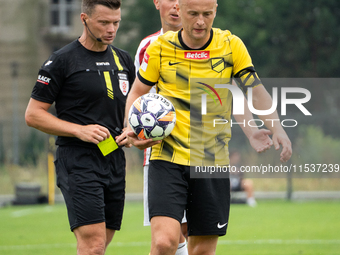 Referee Tomasz Wajda shows a yellow card to Michal Pazdan during a game between Wieczysta Krakow and Pogon Grodzisk Mazowiecki in Krakow, Po...