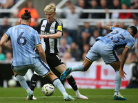 Newcastle United's Anthony Gordon takes on Tottenham Hotspur's Radu Dragusin and Pedro Porro during the Premier League match between Newcast...