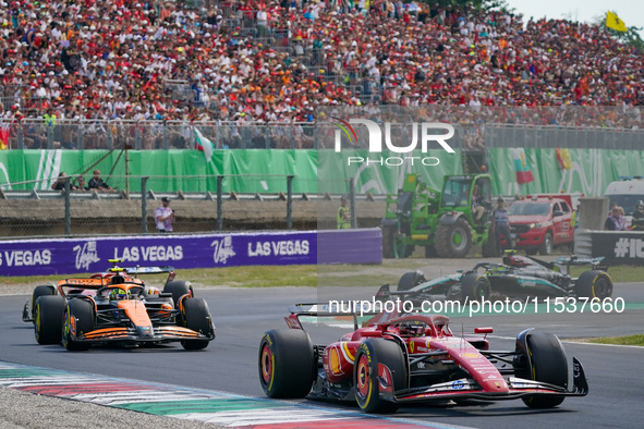 Charles Leclerc of Monaco drives the (16) Scuderia Ferrari SF-24 and Lando Norris of the United Kingdom drives the (04) McLaren F1 Team MCL3...