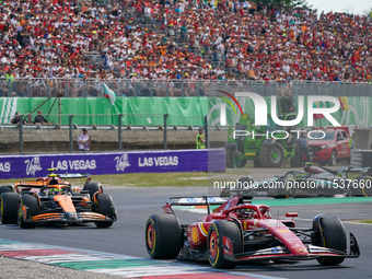 Charles Leclerc of Monaco drives the (16) Scuderia Ferrari SF-24 and Lando Norris of the United Kingdom drives the (04) McLaren F1 Team MCL3...