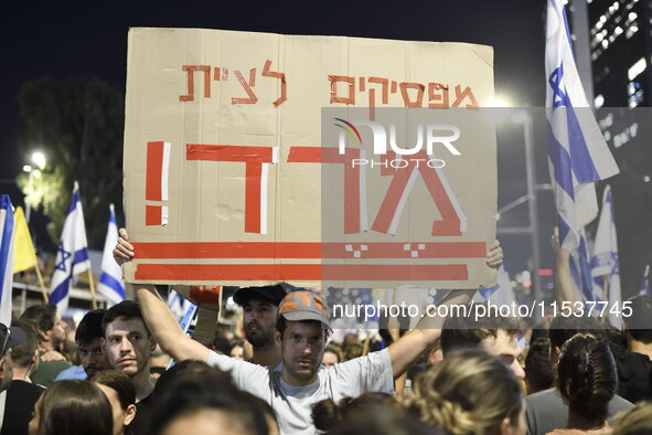 An Israeli protester carries a placard reading ''stop obeying, revolt'' as dozens of thousands of Israelis protest against the Israeli gover...