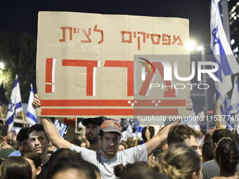 An Israeli protester carries a placard reading ''stop obeying, revolt'' as dozens of thousands of Israelis protest against the Israeli gover...