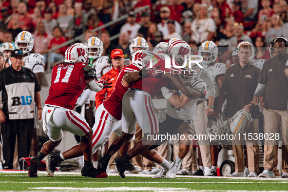 Wisconsin Badgers defense, led by Wisconsin Badgers linebacker Jaheim Thomas #7, swarms Western Michigan quarterback Hayden Wolff #11 at Cam...