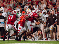 Wisconsin Badgers defense, led by Wisconsin Badgers linebacker Jaheim Thomas #7, swarms Western Michigan quarterback Hayden Wolff #11 at Cam...