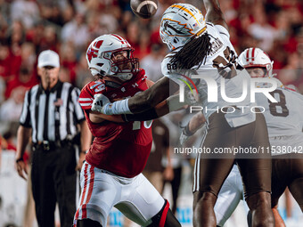 Wisconsin Badgers offensive lineman Jack Nelson #79 holds off Western Michigan defensive lineman Rodney McGraw #99 at Camp Randall Stadium i...