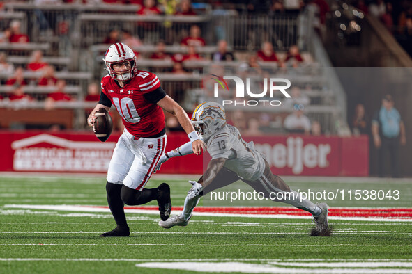 Wisconsin Badgers quarterback Tyler Van Dyke #10 avoids Western Michigan cornerback Nyquann Washington #13 at Camp Randall Stadium in Madiso...