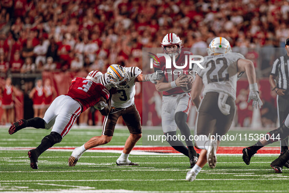 Wisconsin Badgers quarterback Tyler Van Dyke #10 receives help from a Tawee Walker #3 block at Camp Randall Stadium in Madison, Wisconsin, o...