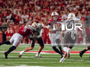 Wisconsin Badgers quarterback Tyler Van Dyke #10 receives help from a Tawee Walker #3 block at Camp Randall Stadium in Madison, Wisconsin, o...