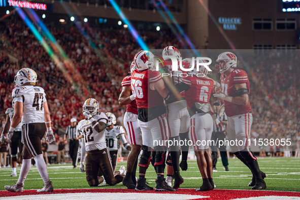 The Wisconsin Badger offense celebrates a touchdown run by Wisconsin Badgers quarterback Tyler Van Dyke #10 against the Western Michigan Bro...