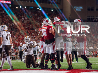 The Wisconsin Badger offense celebrates a touchdown run by Wisconsin Badgers quarterback Tyler Van Dyke #10 against the Western Michigan Bro...