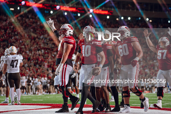 The Wisconsin Badger offense celebrates a touchdown run by Wisconsin Badgers quarterback Tyler Van Dyke #10 against the Western Michigan Bro...