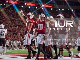 The Wisconsin Badger offense celebrates a touchdown run by Wisconsin Badgers quarterback Tyler Van Dyke #10 against the Western Michigan Bro...