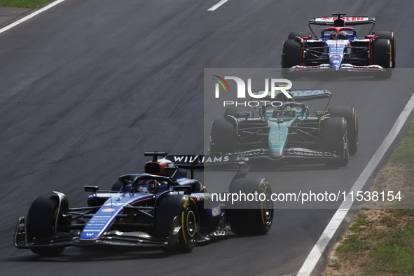 Alexander Albon of Williams, Fernando Alonso of Aston Martin Aramco and Daniel Ricciardo of RB during the Formula 1 Italian Grand Prix at Au...