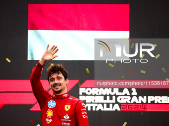 Charles Leclerc of Ferrari celebrates on the podium after winning the Italian Formula One Grand Prix at Autodromo Nazionale Monza circuit, i...