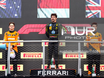 Charles Leclerc of Ferrari, Oscar Piastri of McLaren and Lando Norris of McLaren are seen on the podium after winning the Italian Formula On...