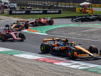 Lando Norris of McLaren, Charles Leclerc of Ferrari, Oscar Piastri of McLaren and other drivers drive after the start of the Italian Formula...