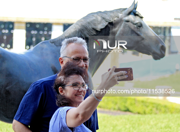 Race fans take a selfie in front of the statue of Kentucky Derby and Queen's Plate-winning Canadian racehorse Northern Dancer at Woodbine Ra...