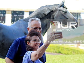 Race fans take a selfie in front of the statue of Kentucky Derby and Queen's Plate-winning Canadian racehorse Northern Dancer at Woodbine Ra...