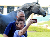 Race fans take a selfie in front of the statue of Kentucky Derby and Queen's Plate-winning Canadian racehorse Northern Dancer at Woodbine Ra...