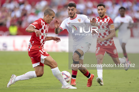 Isaac Romero of Sevilla FC competes for the ball with Oriol Romeu of Girona FC during the La Liga EA Sports match between Sevilla FC and Gir...